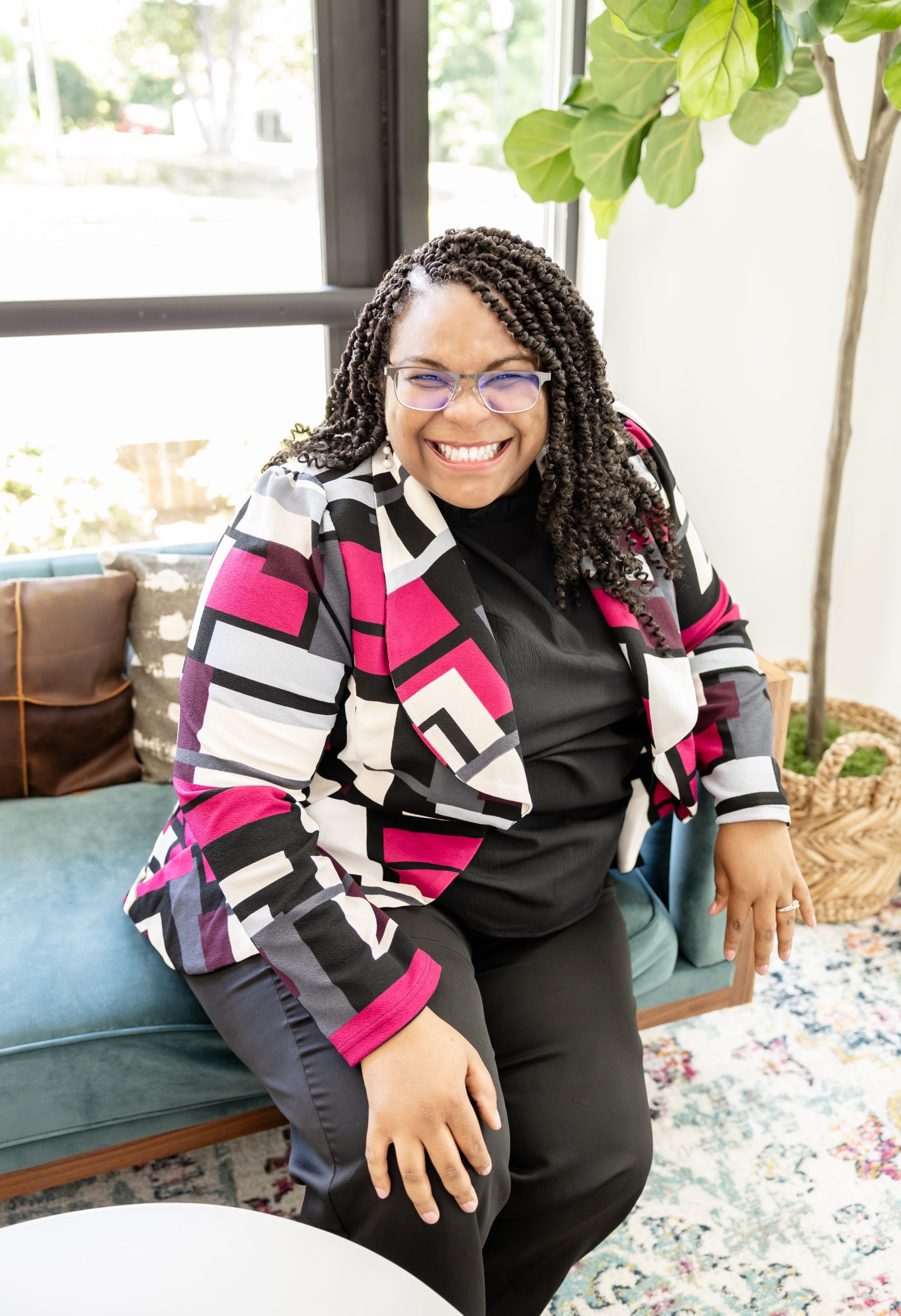 Anitra Deen smiling in a patterned blazer